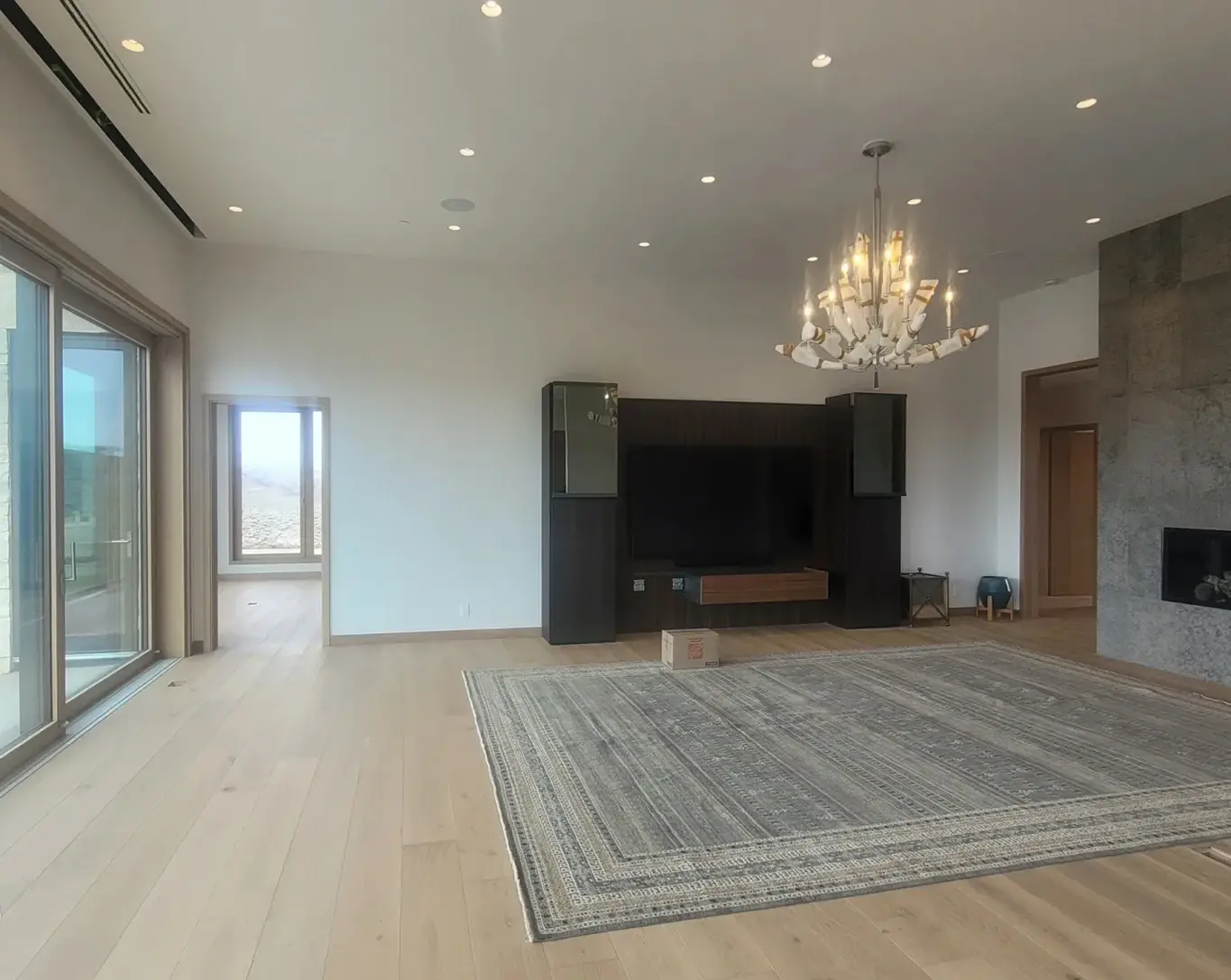 Spacious living room with chandelier and fireplace.