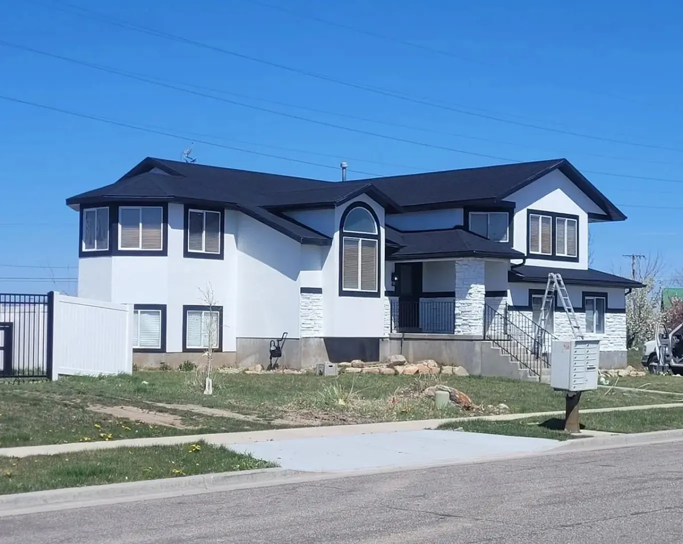 Modern two-story house with black roof.