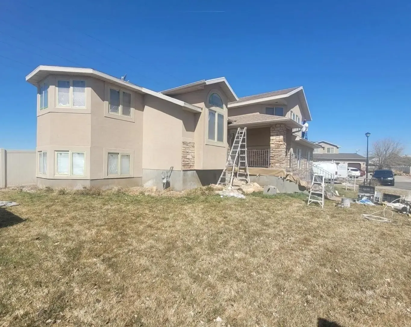 House exterior with ladders and construction materials.