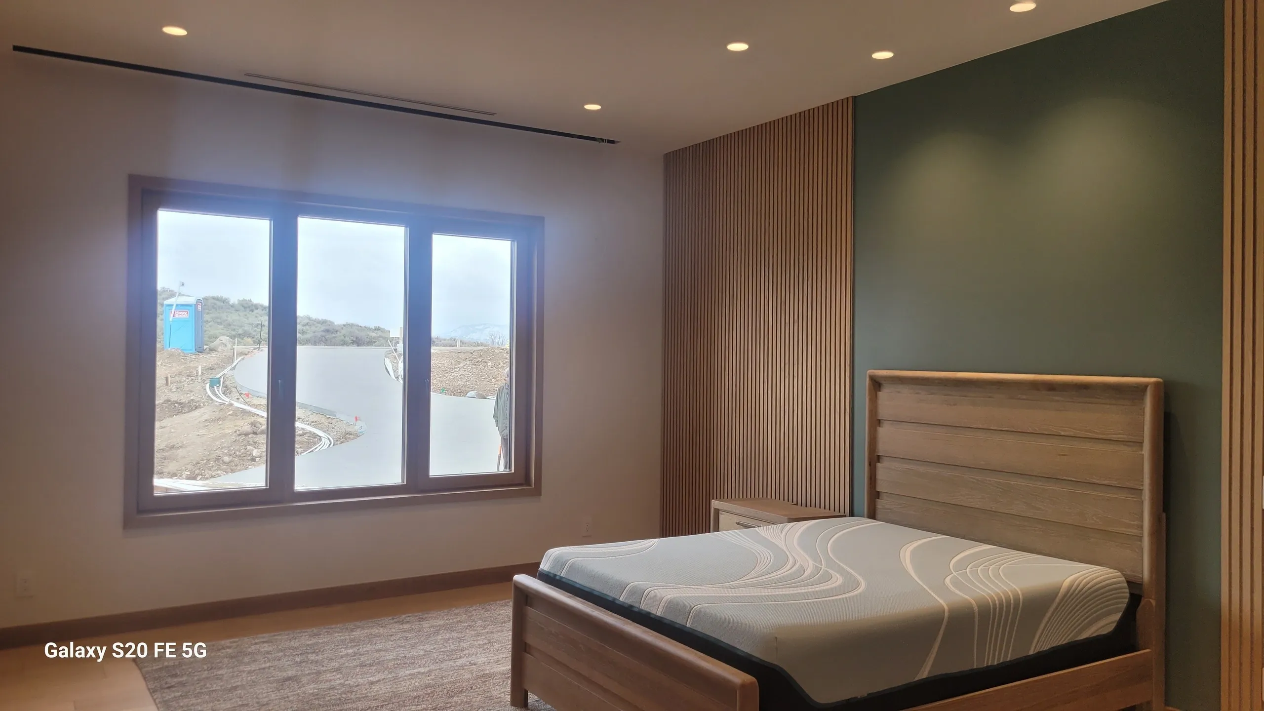 Modern bedroom with large window view.