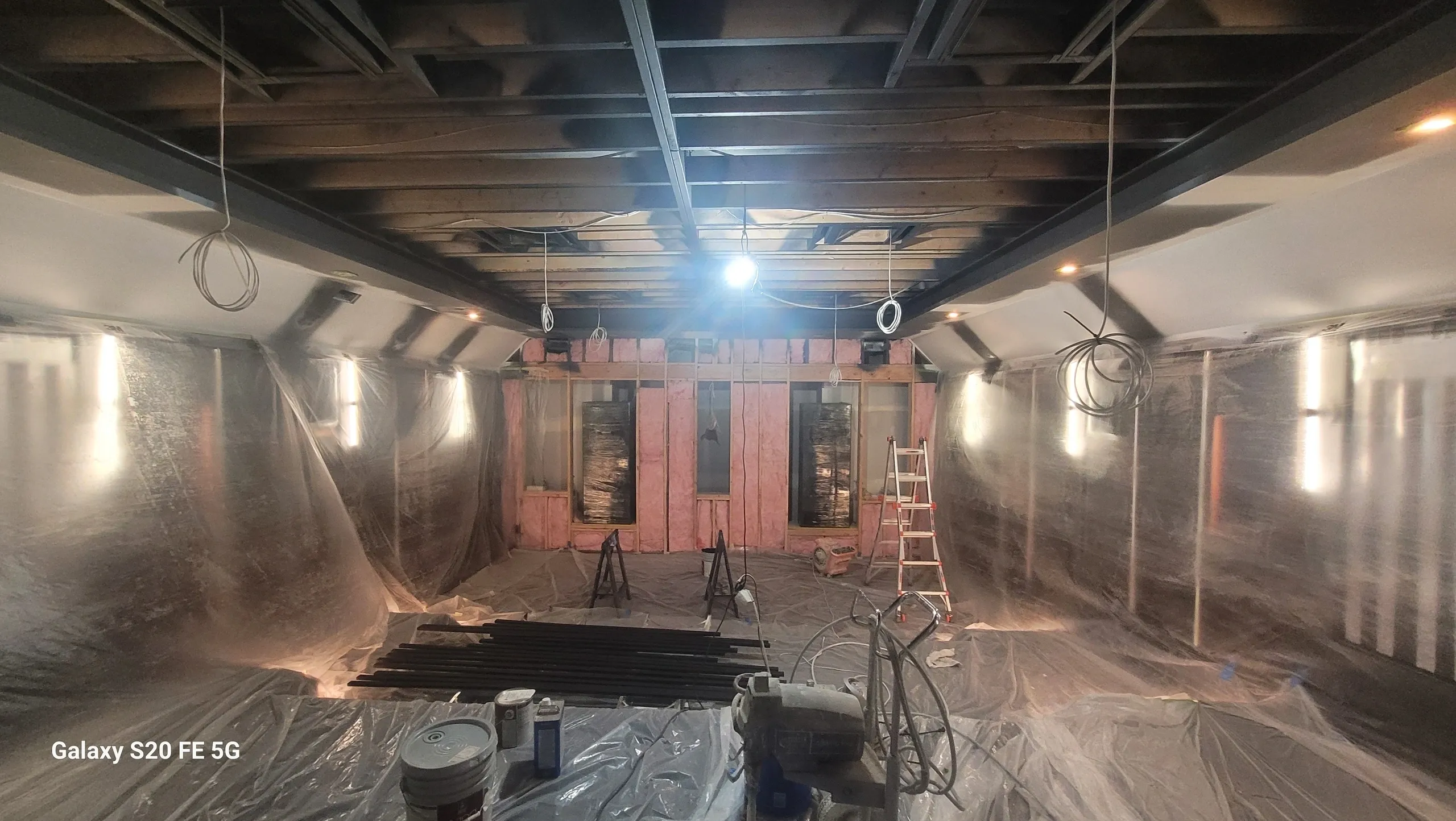 Room under construction with plastic coverings.